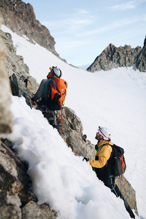Two climbers on a snowy mountain with backpacks