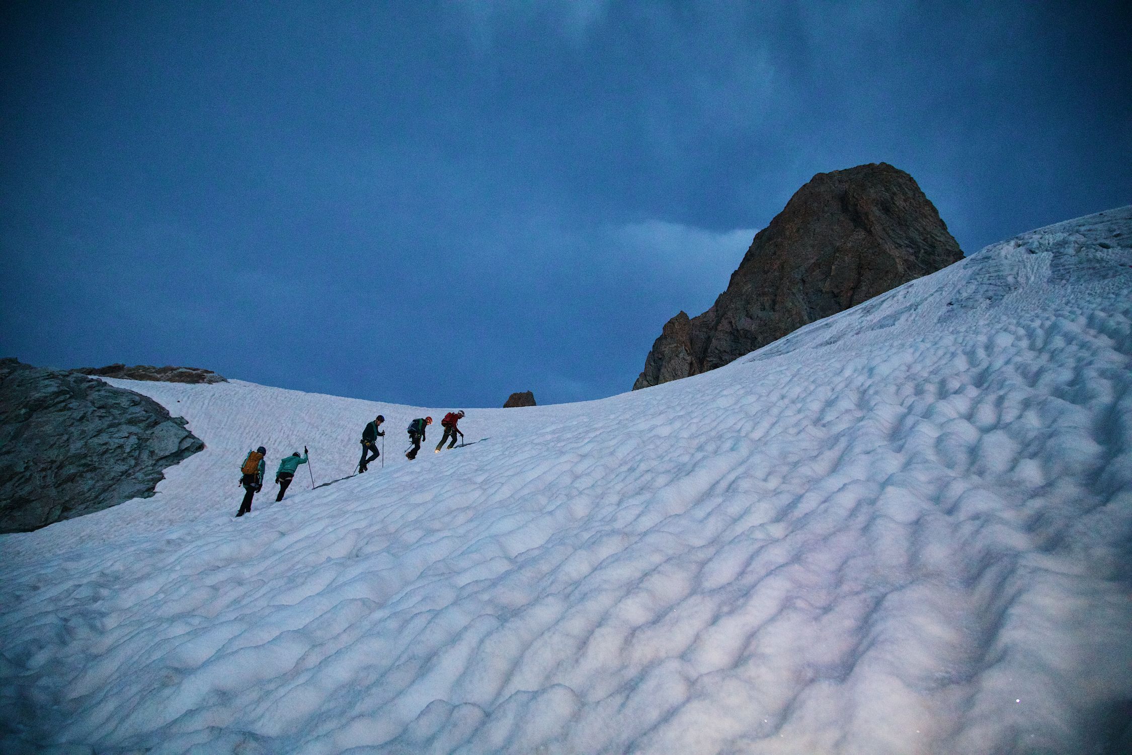 A group of people walking up a snowy mountain · Free Stock Photo