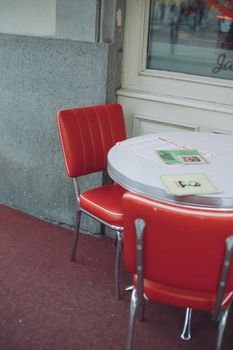 Retro red chairs and table setup outside a cafe in Prague.