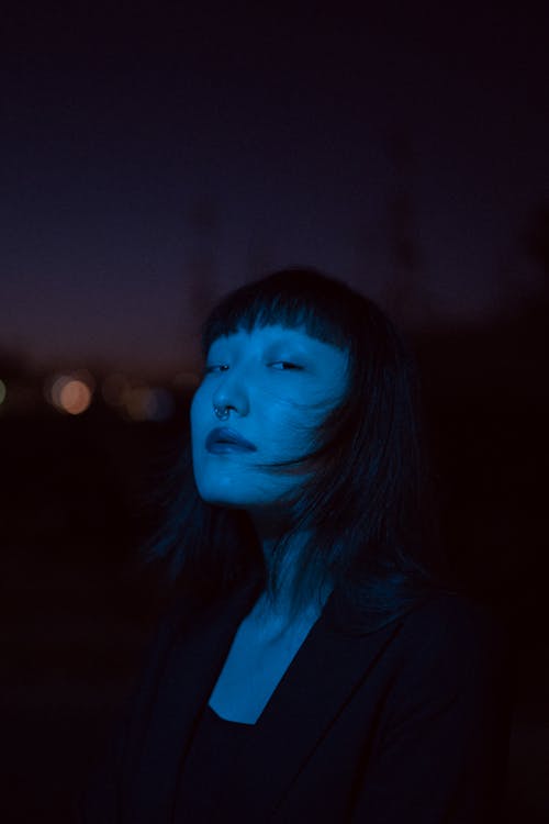 Young Woman in Elegant Black Blazer Posing Outdoors at Night