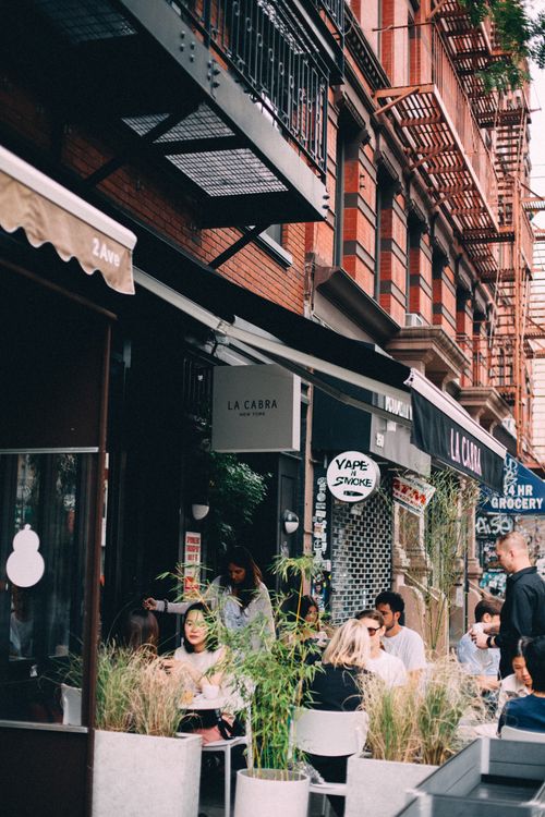 Free People socializing at an outdoor café on a vibrant New York street, capturing urban life. Stock Photo