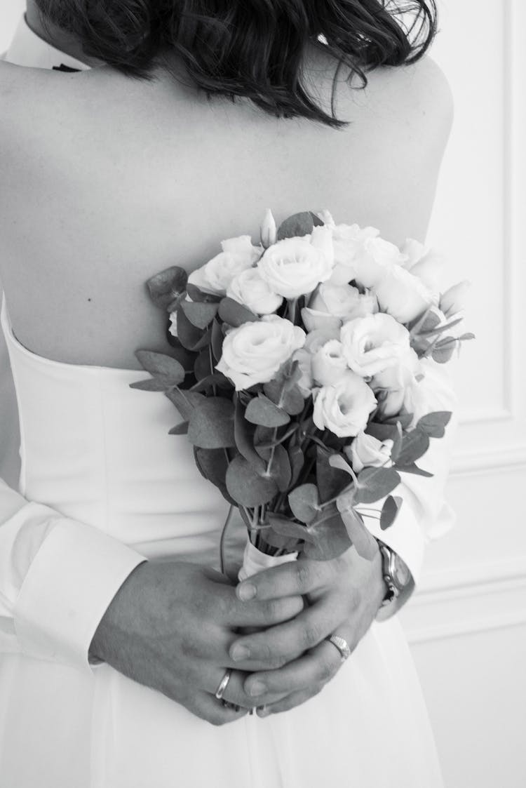 Bride Holding Bouquet Of White Roses