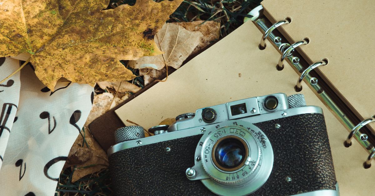 Camera Notepad Analog Camera Lying on Open Notebook · Free Stock Photo