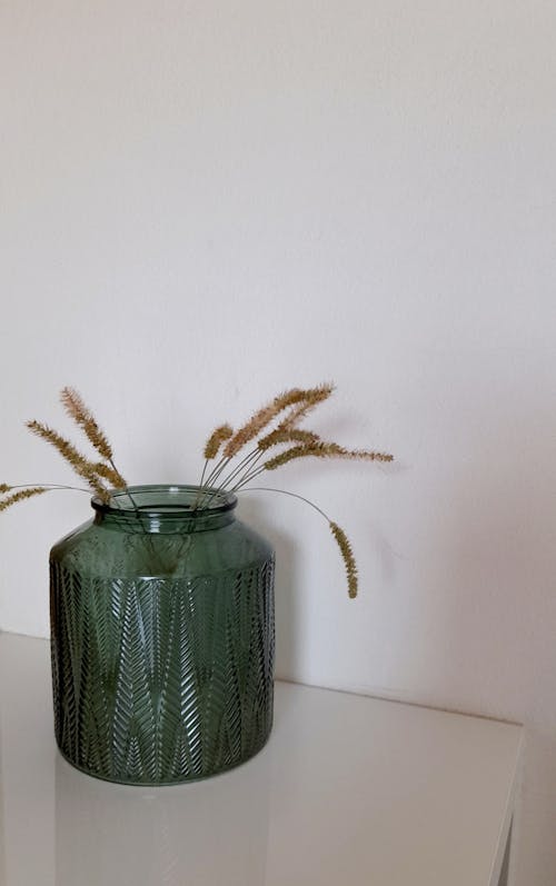 Grass Straw in Green Glass Vase on White Table