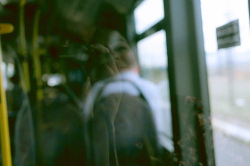 Photographer Mirroring in Interior Window of Bus