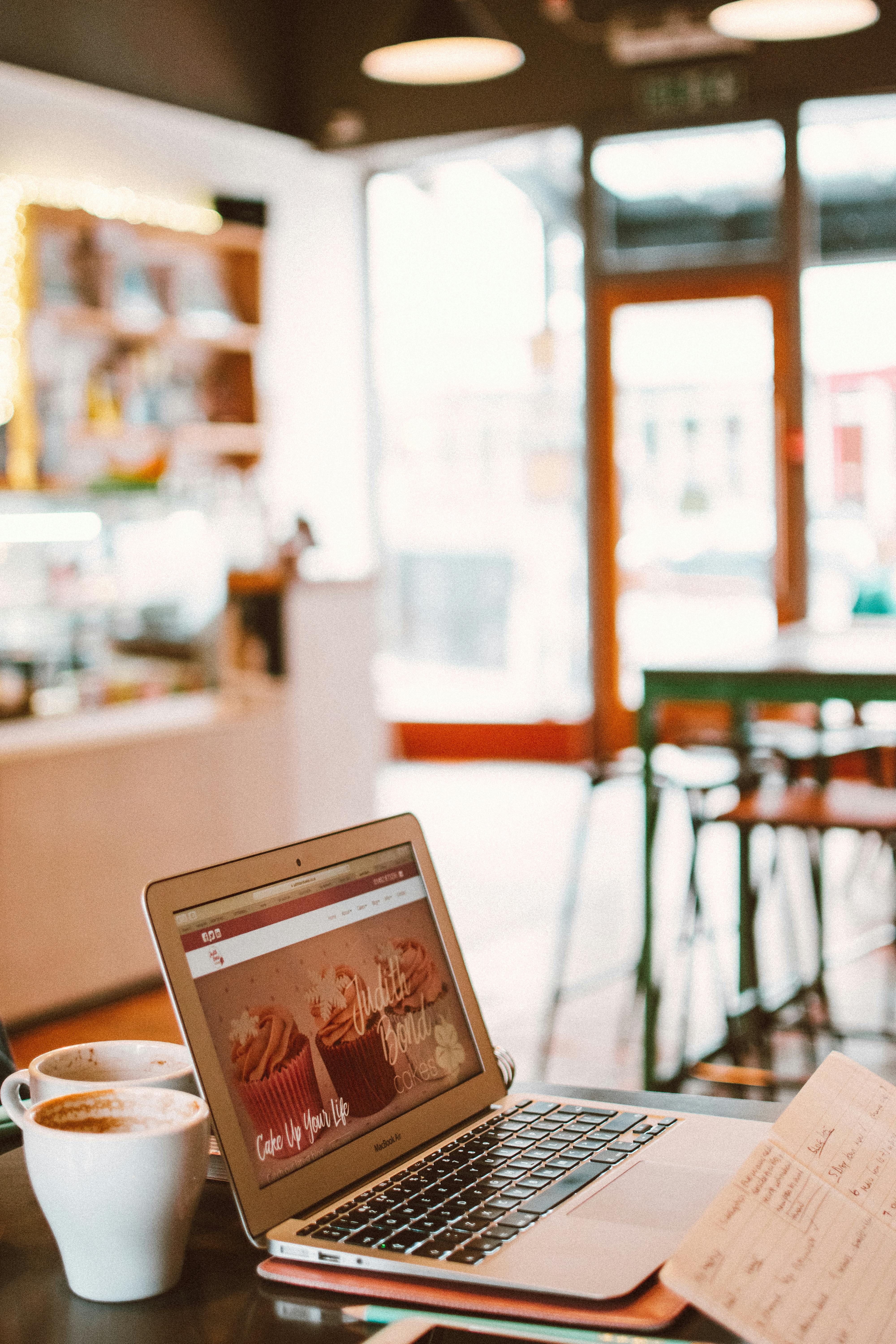 photo of laptop beside white mug