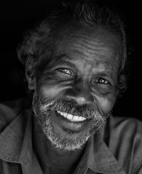 Free Captivating black and white portrait of a smiling elderly man with a beard, showcasing expressive features. Stock Photo