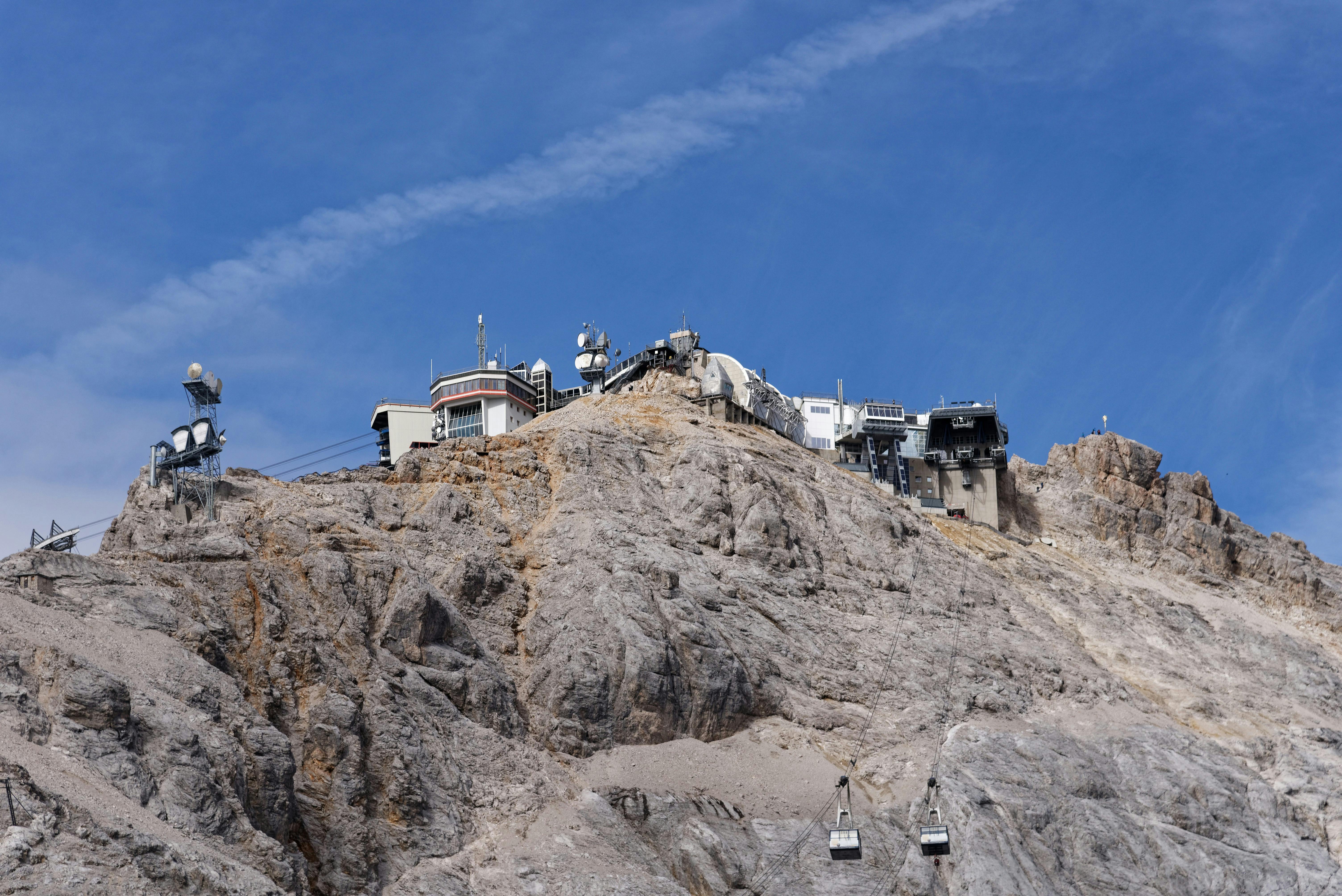 Scenic view of Zugspitze peak with ski lift under clear blue skies in Germany.