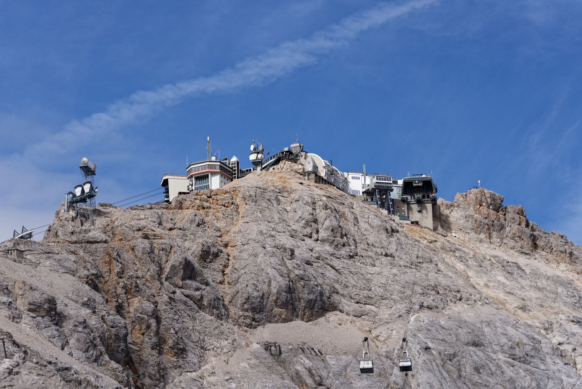 Scenic view of Zugspitze peak with ski lift under clear blue skies in Germany.