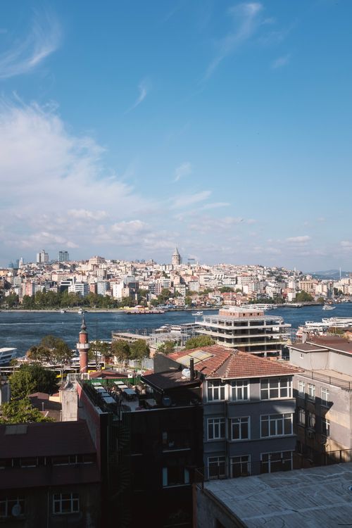 Free Panoramic view of Istanbul's cityscape, featuring the iconic Galata Tower across the Bosphorus under a clear summer sky. Stock Photo