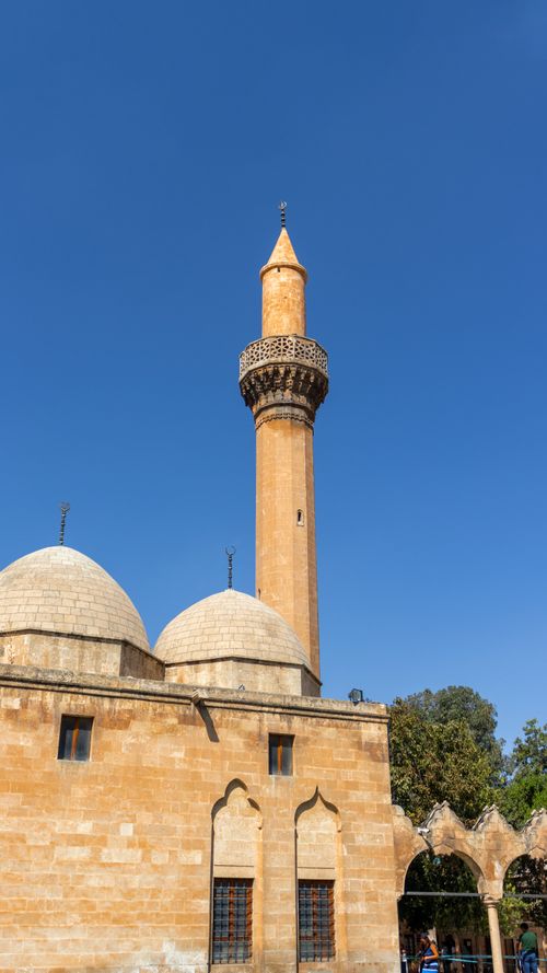 Free Sunlit minaret of Rizvaniye Mosque against a clear blue sky in Şanlıurfa, Türkiye. Stock Photo