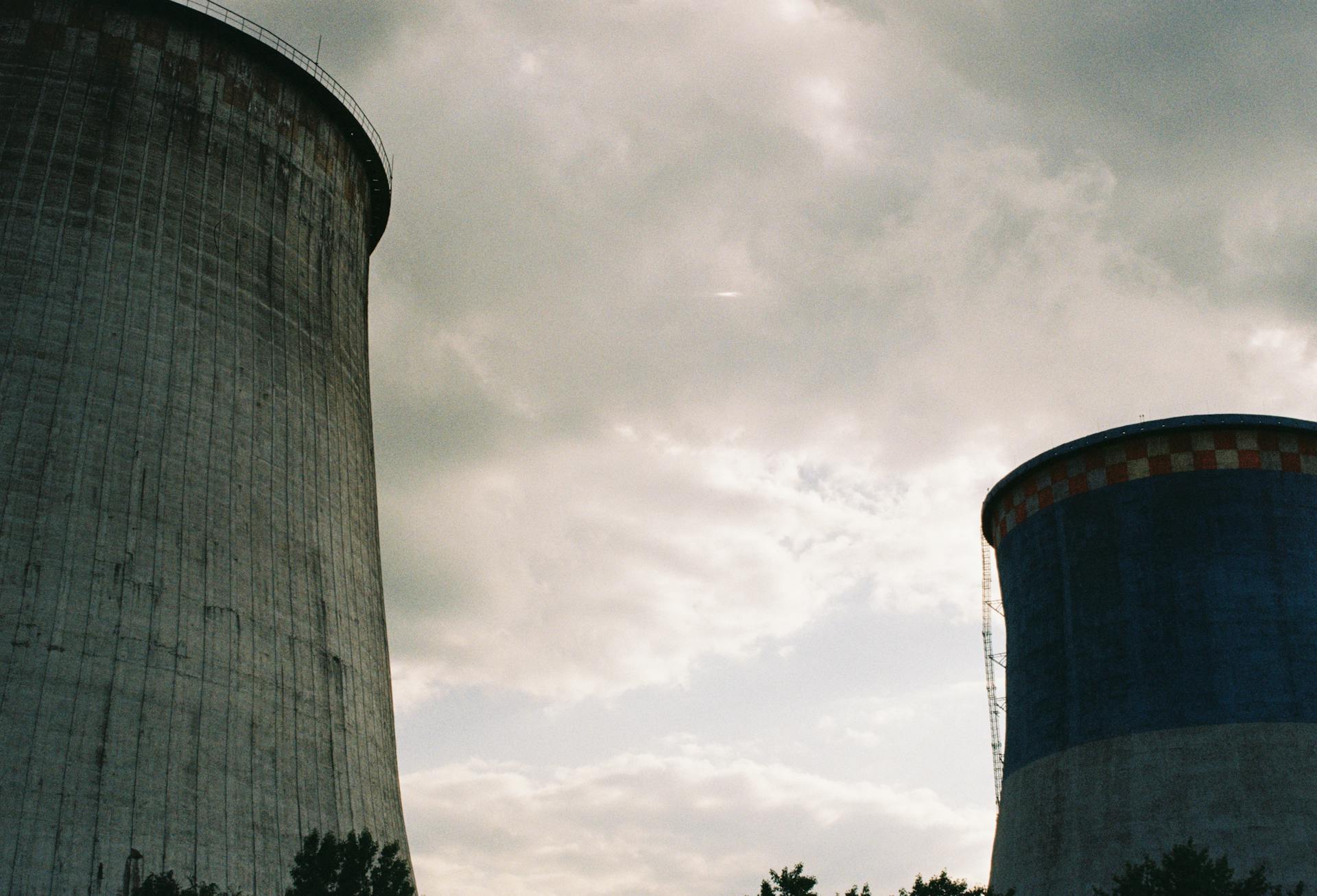 Imposing cooling towers of a nuclear power station under a cloudy sky, showcasing industrial architecture.