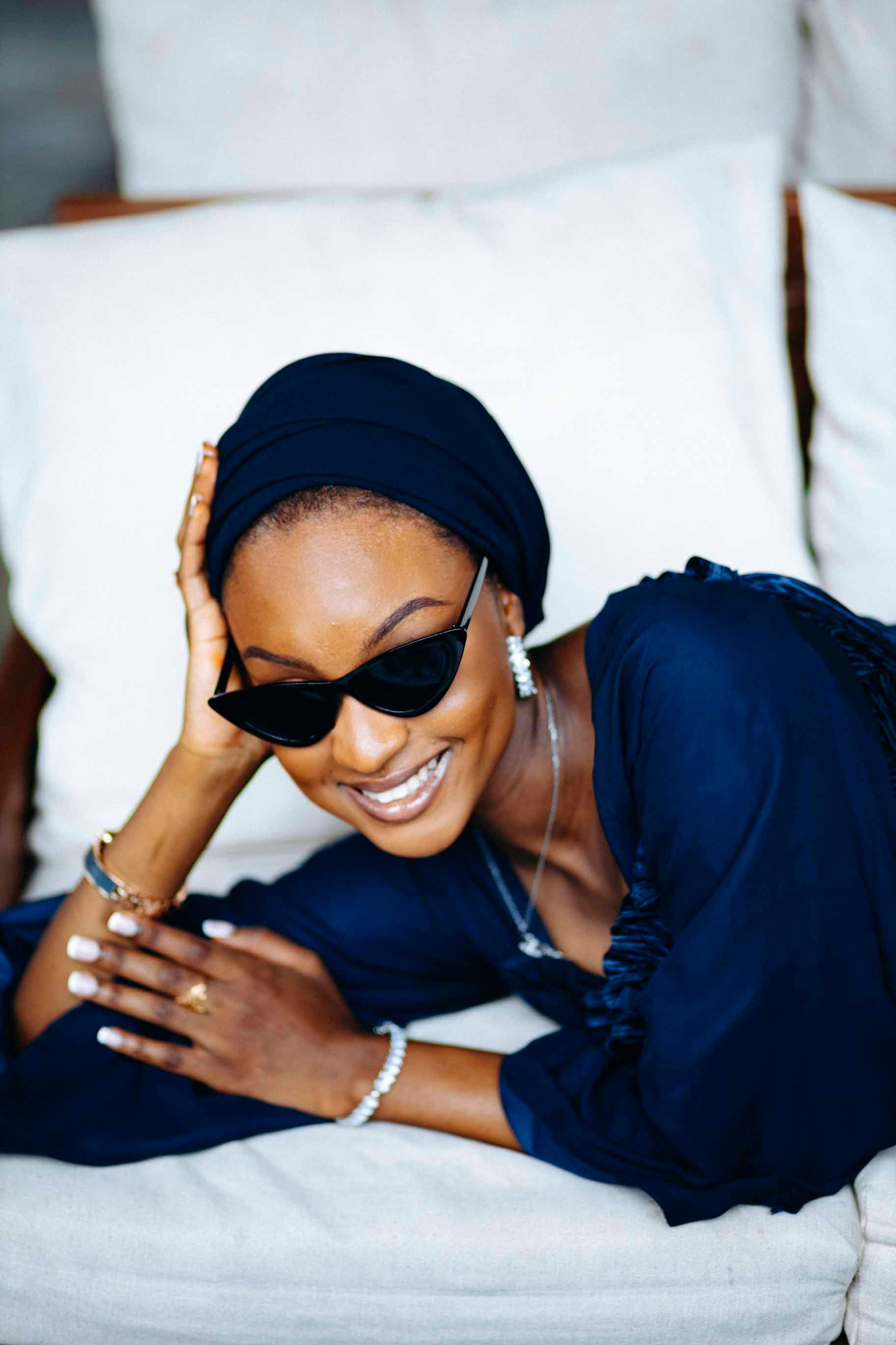 Smiling Woman in Blue Navy Lying on Sofa · Free Stock Photo