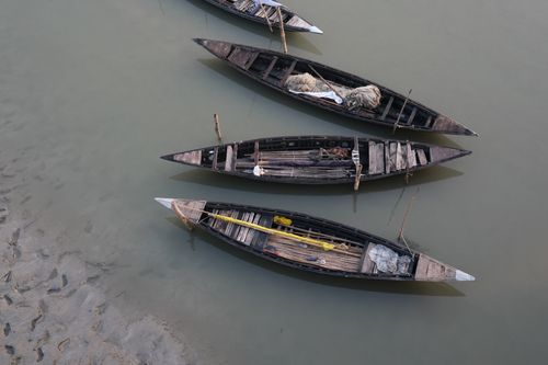 Free Top view of empty traditional wooden boats lined up near a sandy shore. Stock Photo