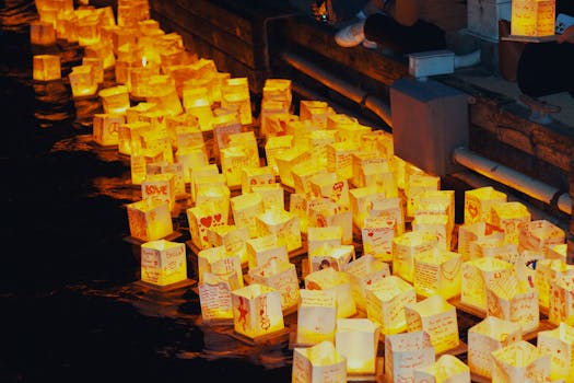 Illuminated lanterns floating on water during the Detroit Water Lantern Festival at night.