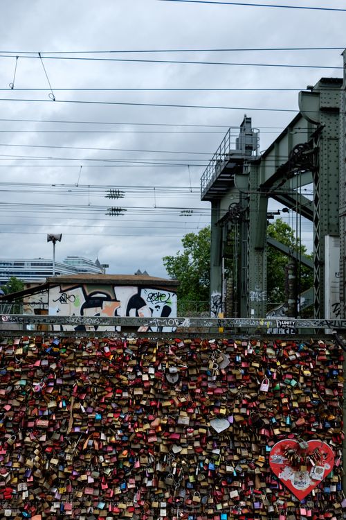Free Colorful love locks on Hohenzollern Bridge, Cologne, symbolize eternal affection against a backdrop of industrial architecture. Stock Photo