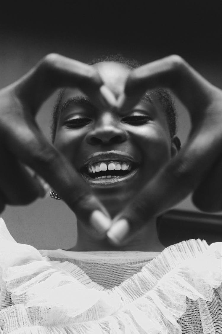 Smiling Woman Showing Heart Made With Fingers