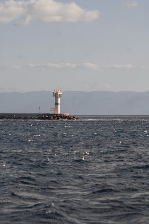 dağlar, deniz, deniz feneri içeren Ücretsiz stok fotoğraf