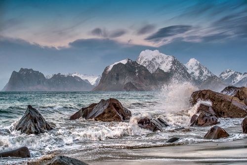 Free Beautiful coastal view of Lofoten Islands with rocky beach and snowy peaks. Stock Photo