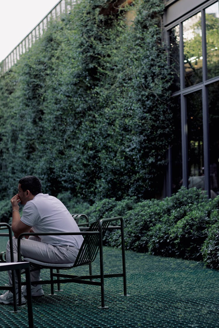 A Man Sitting On A Chair On A Patio