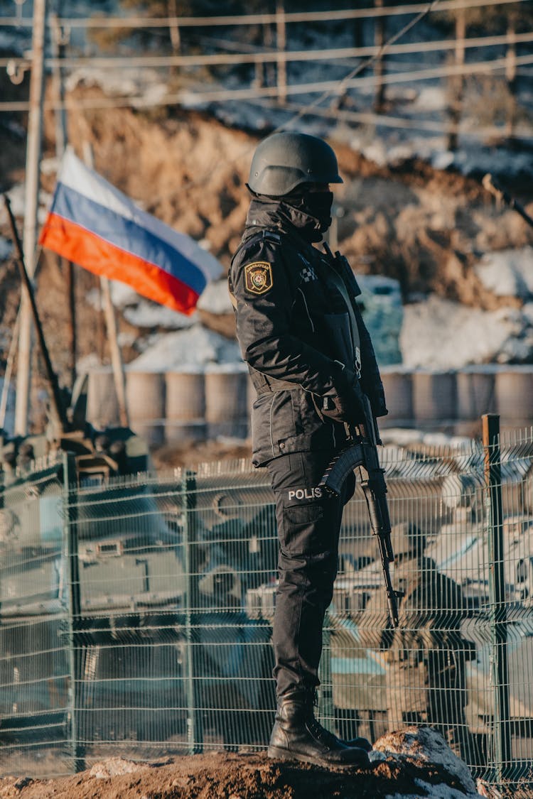 Police Officer With Automatic Rifle Guarding Border With Russia