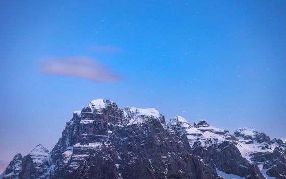 Captivating view of the snowy Alps under a clear, starry night sky. Perfect for adventure and nature enthusiasts.