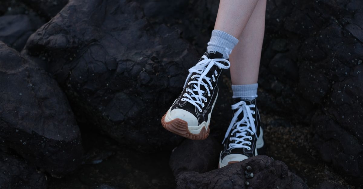 Stylish sneakers on rocks, captured outdoors in Mumbai, India.