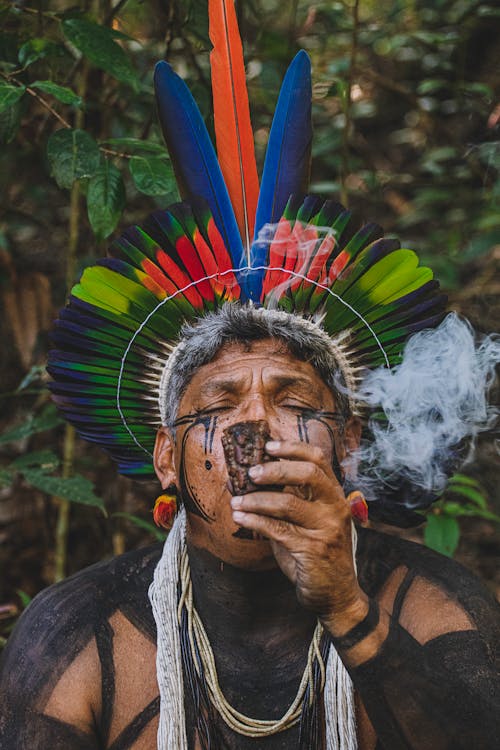 Man in Traditional Plume Smoking Pipe