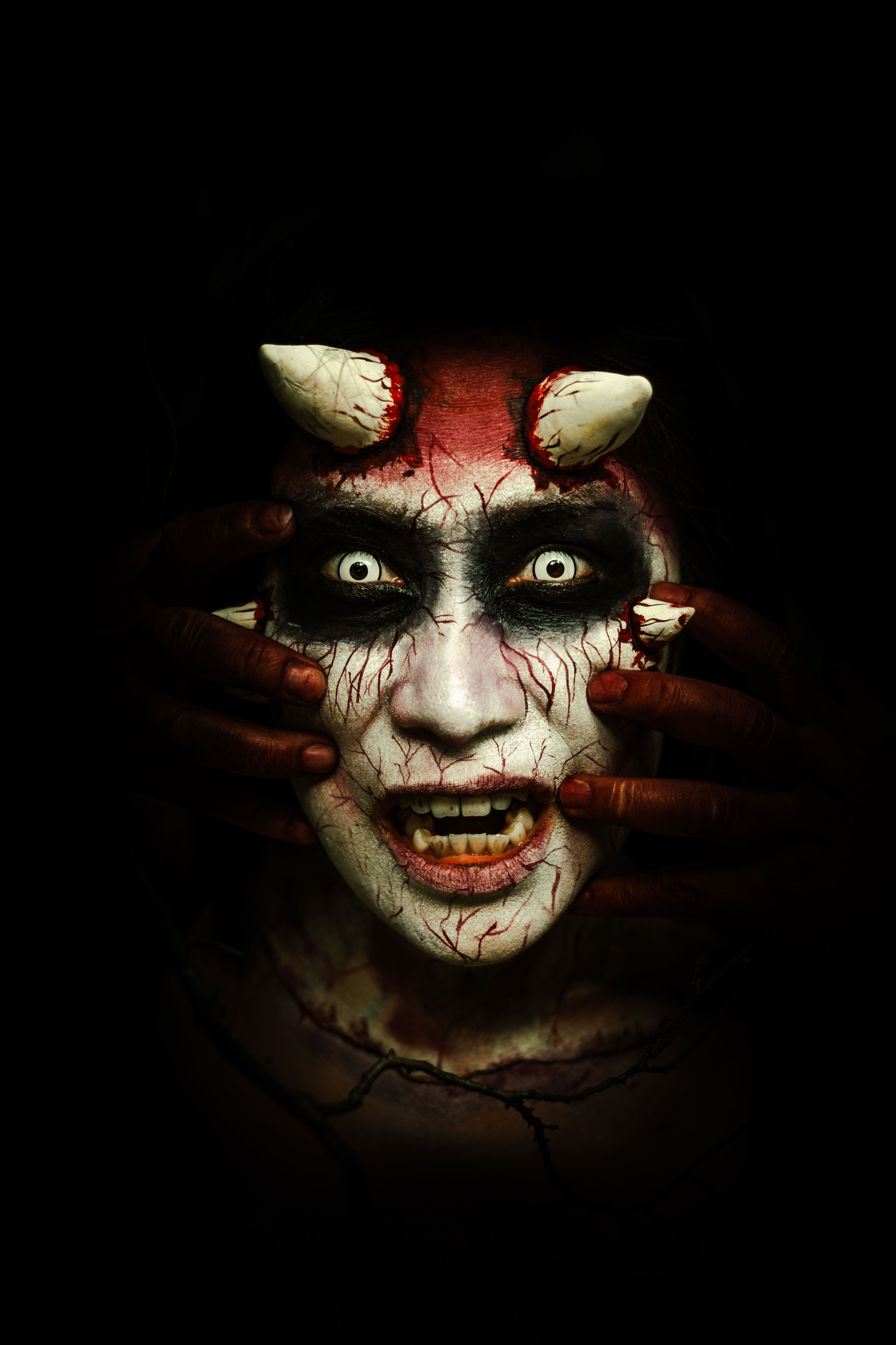 Close-up portrait of a person with devil makeup and horns, perfect for Halloween themes.