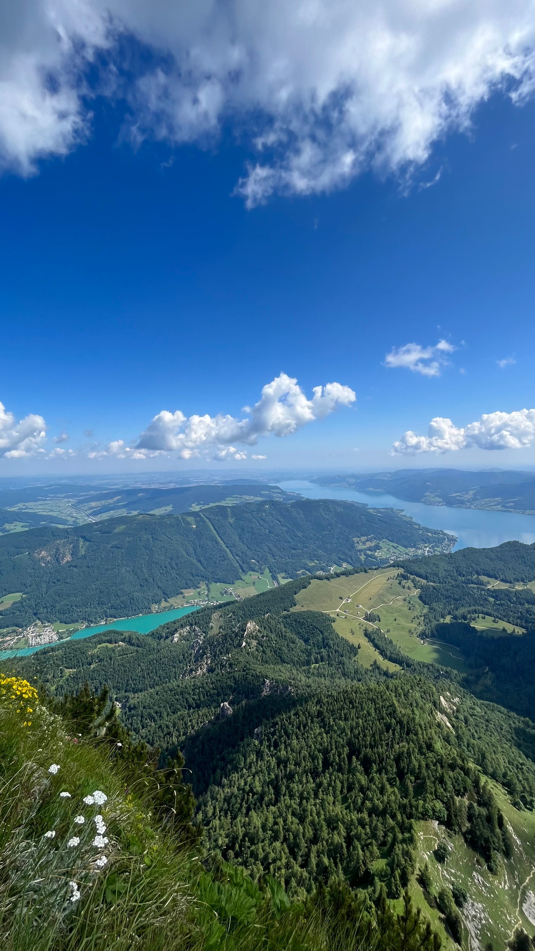 Fotomural Impresionante vista de montañas verdes y lagos azules bajo un cielo claro de verano.
