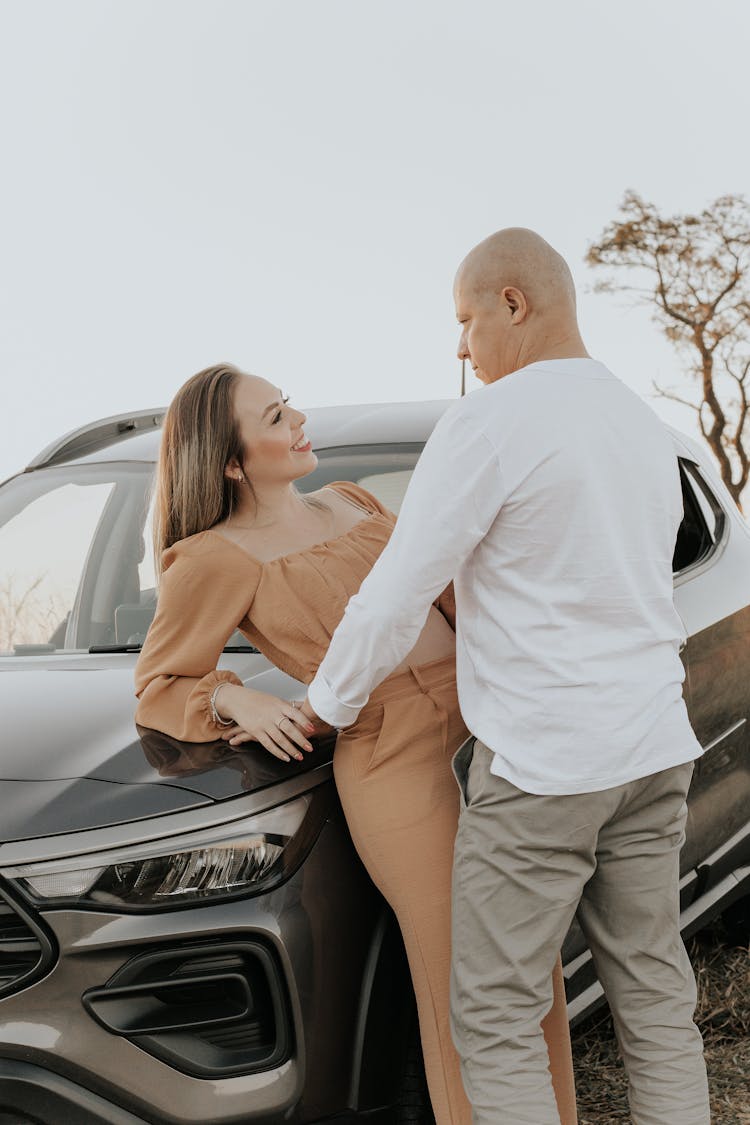 Smiling Couple Standing By Car