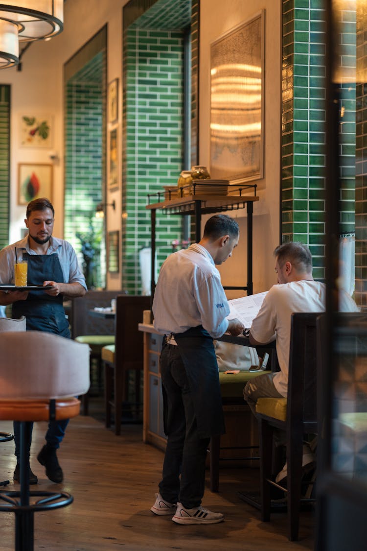 Customer Ordering Meal At Table In Restaurant