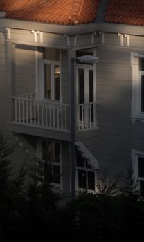 A detailed view of a mansion's exterior featuring balconies and large windows, creating a luxurious ambiance.
