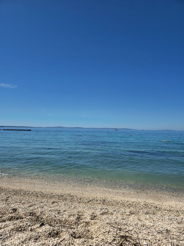 Praia pristine com águas cristalinas e céu azul em Split, Croácia.