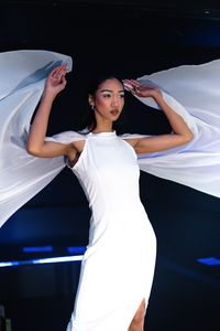 A model in a white draped dress on the runway — photo by Marcus Queiroga Silva on Pexels