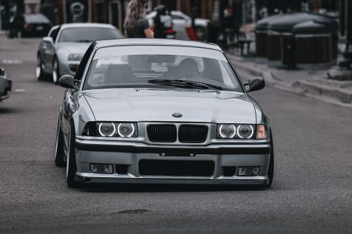 Free A sleek silver sedan is seen navigating busy urban city streets, showcasing urban driving dynamics. Stock Photo