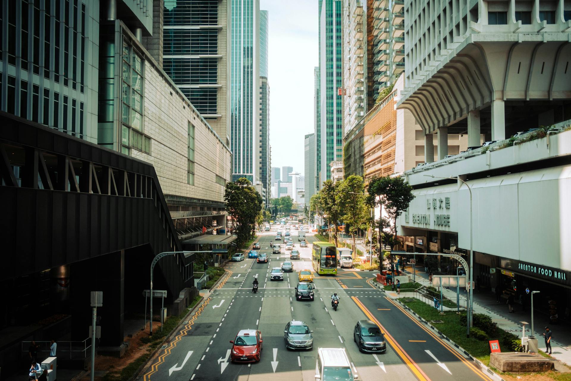 A bustling street in Singapore showcasing modern skyscrapers and urban traffic.