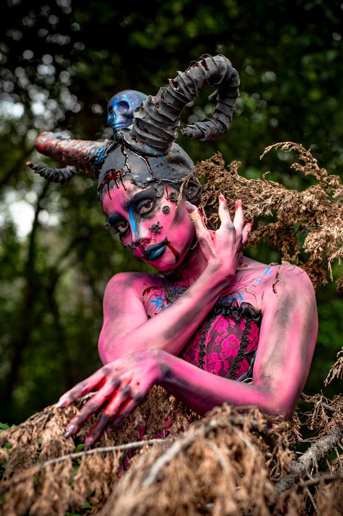 Free Gothic styled woman with horns in a fantasy costume poses dramatically outdoors. Stock Photo