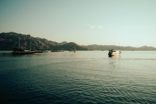 Free Tranquil scene of boats anchored in the calm waters of Komodo National Park. Stock Photo