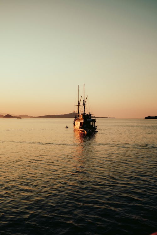 Ship Sailing on Tranquil Sea at Sunrise