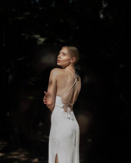 Model in a White Backless Dress Looking Over Her Shoulder