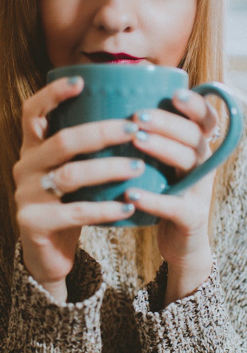 女人抱着蓝色陶瓷杯