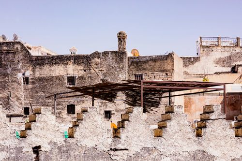 Free Weathered stone buildings in an urban setting with clear skies, showcasing historical architecture. Stock Photo
