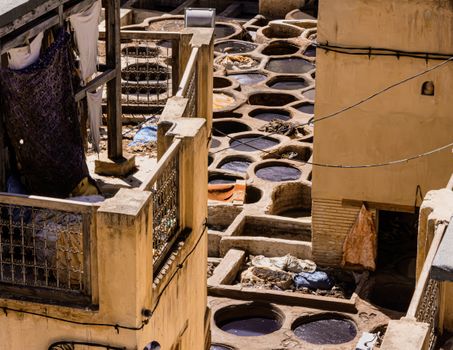 Aerial view of a traditional tannery with circular dyeing vats used for leather processing.