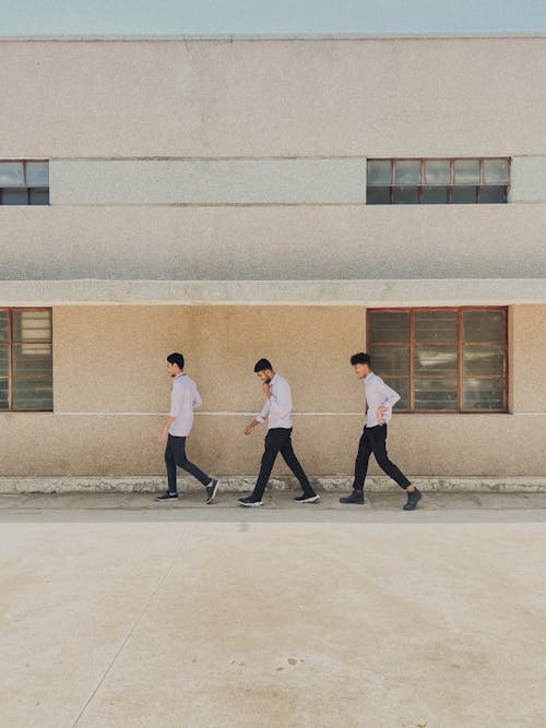 Men Walking in Line under Building