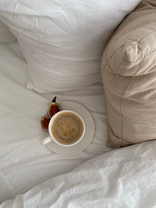 Free Cup of Coffee and Pillows on a Bed  Stock Photo