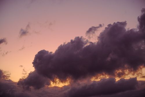 Free A beautiful scene of dramatic clouds against a vibrant sunset sky, creating a captivating atmosphere. Stock Photo