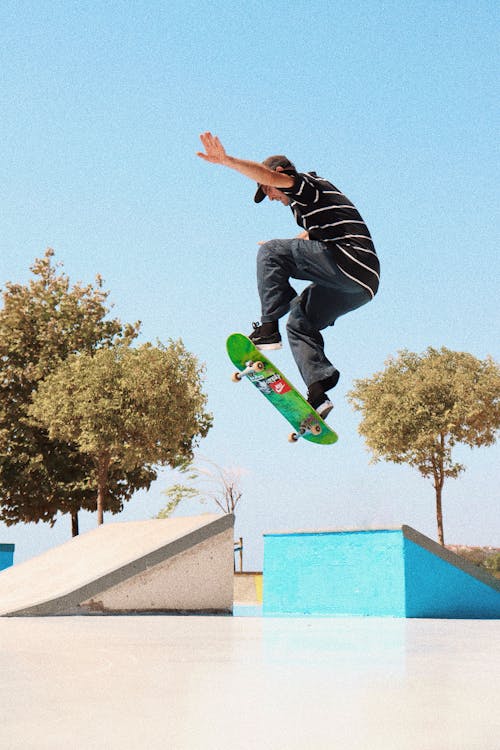Man Jumping with Green Skateboard