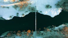 从空中俯瞰，一条宁静的河流在冬季被白雪和树木环绕