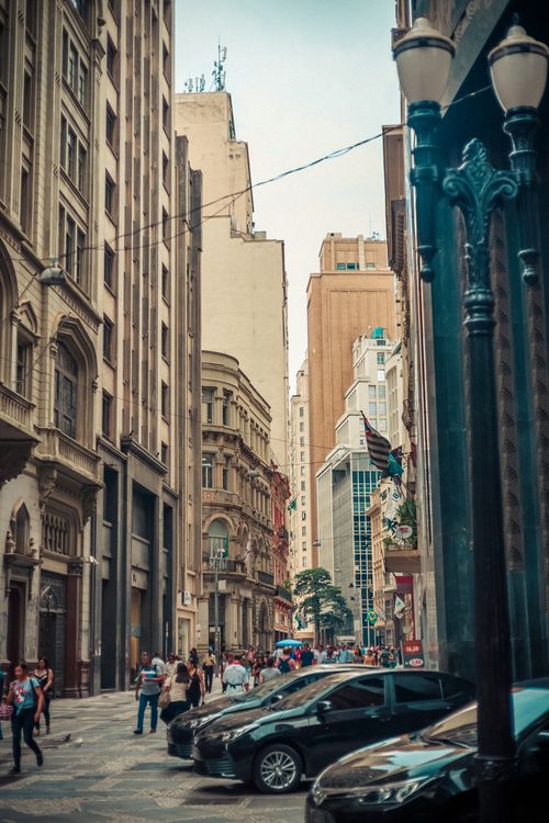 Free Vibrant city street scene featuring historic buildings and pedestrians in lively urban area. Stock Photo